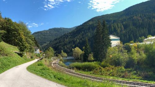 a winding road next to a river with mountains at Riverside Ski Apartment in Ramingstein