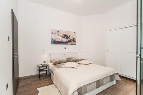 a bedroom with a bed and a painting on the wall at Apartment Mille in Rijeka