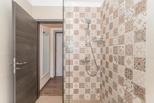 a bathroom with a shower with a tile wall at Apartment Mille in Rijeka