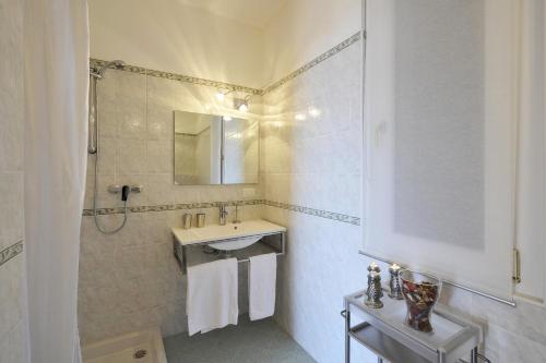 bagno bianco con lavandino e specchio di Alto Perledo Terrazzo a Perledo