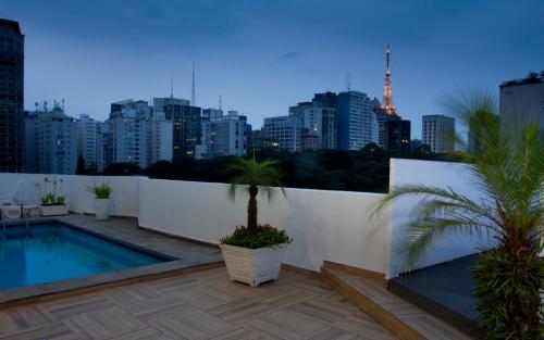 a balcony with a swimming pool and a city skyline at Hotel Trianon Paulista in Sao Paulo