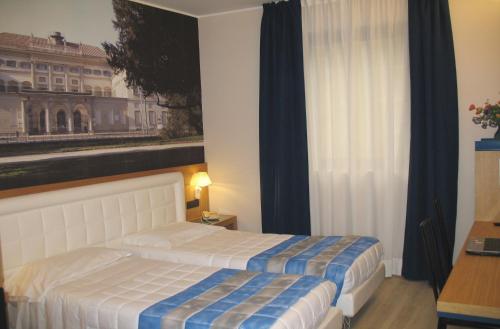 a bedroom with a bed and a picture of a building at Hotel Domenichino in Milan