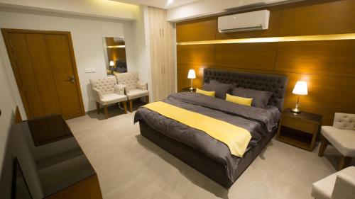 um quarto com uma cama grande e uma cadeira em SPACE Luxury Rental Suites em Rawalpindi