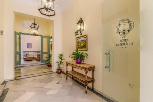a lobby with a table and a sign on the wall at Hotel La Española in Chipiona