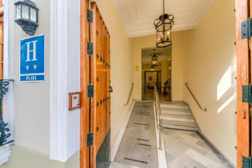 a hallway of a building with stairs and a sign on the wall at Hotel La Española in Chipiona