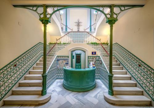 a staircase in a house with a green door at Hotel La Española in Chipiona