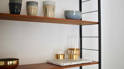 a shelf with bowls and glasses on it at huisalfons in Mechelen
