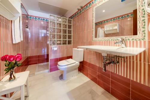 
a bathroom with a toilet, sink, and tub at Hotel La Española in Chipiona
