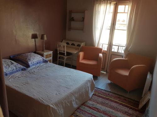 a bedroom with a bed and two chairs and a window at Chez Vivi in Ria