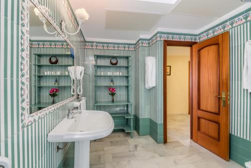 ein Bad mit einem Waschbecken und einem Spiegel in der Unterkunft Hotel La Española in Chipiona