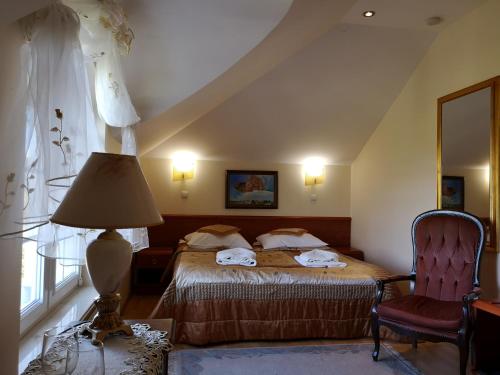 a bedroom with a bed and a lamp and a chair at Pensjonat Błękitny Anioł in Kiersztanowo