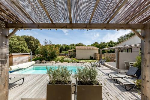 a backyard with a swimming pool and a pergola at Songes d’été in Bonifacio