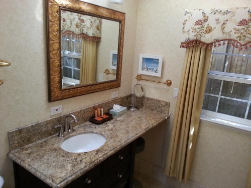 a bathroom with a sink and a mirror at The Vendange Carmel Inn & Suites in Carmel
