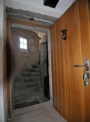 a hallway with a staircase in a house with a window at Le Passage in La Charité-sur-Loire