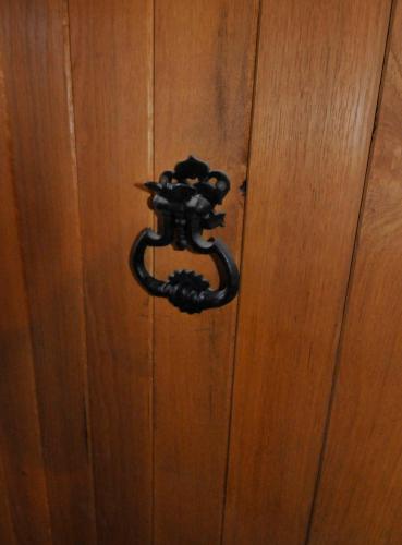 a black door knocker on a wooden door at Le Passage in La Charité-sur-Loire
