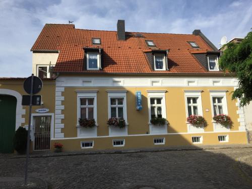 un bâtiment jaune et blanc avec un toit rouge dans l'établissement pension & sauna AM LORENZ, à Calbe