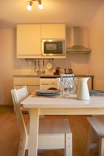 a kitchen with a white table with chairs and a microwave at Revigora in Vienne