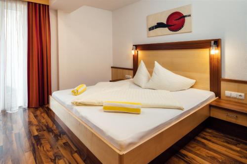 a bedroom with a bed with two yellow towels on it at Apart Sunshine in Ladis