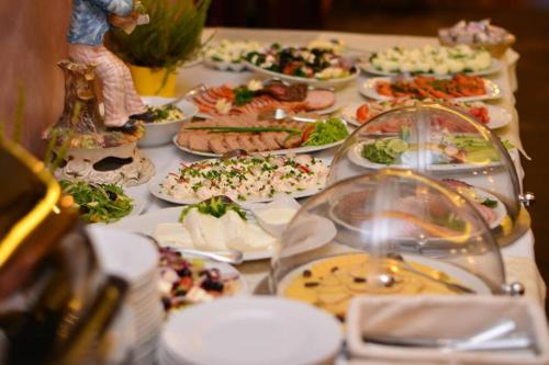 a table topped with plates of food at Borowinowy Zdrój Hotel Wellness Spa & Conference in Supraśl