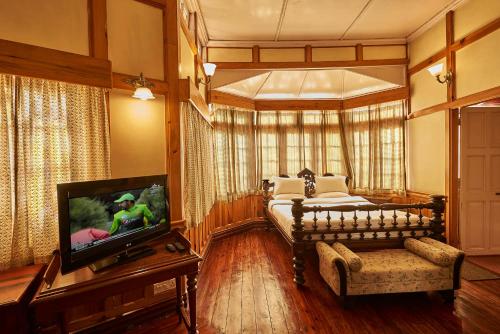 a bedroom with a bed and a tv in it at The Heritage Club - Tripura Castle Hotel and Spa in Shillong