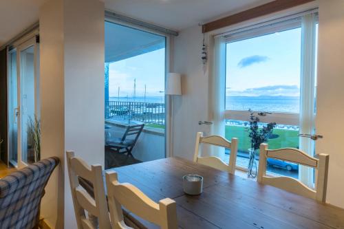 a dining room with a table and a view of the ocean at Modern apt, amazing harbour views, wifi & parking in Musselburgh