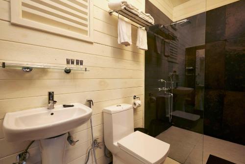 a bathroom with a toilet and a sink and a shower at The Heritage Club - Tripura Castle Hotel and Spa in Shillong