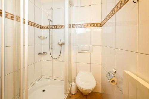 a white bathroom with a shower and a toilet at Försterli Ost in Grächen