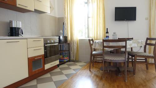 a kitchen with a table and a dining room at Apartments Lena in Podgora