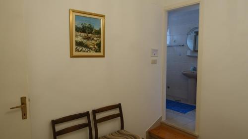 a bathroom with a toilet and a picture on the wall at Apartments Lena in Podgora