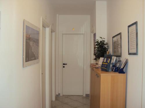 a hallway with a white door and a wooden cabinet at B&B Brezza Marina & Ristorante Shoreline in Pozzallo