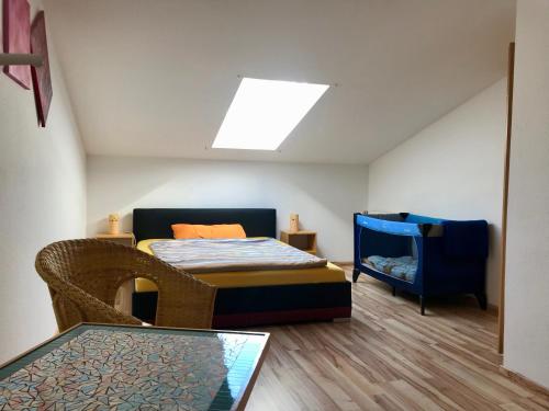 um pequeno quarto com uma cama e uma cadeira em Ferienwohnung am Eiskeller em Ankershagen