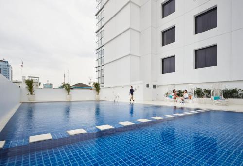 a swimming pool in front of a building at de Braga, ARTOTEL Curated in Bandung
