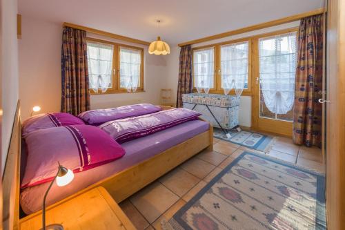 een slaapkamer met een groot bed met paarse kussens bij Paradiso 2 in Grächen