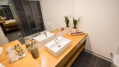 La salle de bains est pourvue d'un lavabo et d'un miroir. dans l'établissement Bugalha My Loft Douro 10, à Peso da Régua