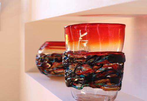 two colorful glass vases sitting on a shelf at Palazzo Vendramin Costa in Venice