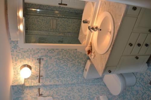 a bathroom with a sink and a toilet and a mirror at Teresa Spiti in Adamantas