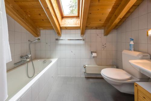 een badkamer met een bad, een toilet en een wastafel bij Spieliweida in Grächen