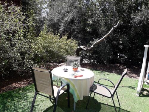 a table with two chairs and a white table cloth on it at Mazal shell Zimmer in Amirim