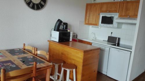 a small kitchen with a table and a microwave at Charmant T2 avec cabine fermée et terrasse in Les Angles