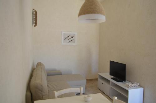 a living room with a couch and a television at Marinelli Guest House in Cisternino