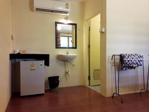baño con lavabo y nevera blanca en M&M Guesthouse en Ko Chang