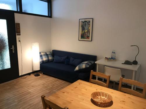 ハーゲンにあるMonteurhome-Hagenの青いソファとテーブルのあるリビングルーム