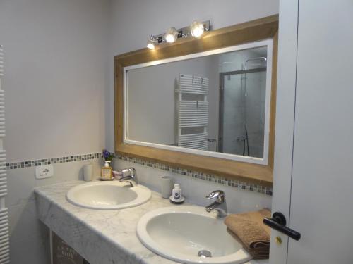 a bathroom with two sinks and a large mirror at Covo Giulia in Genoa