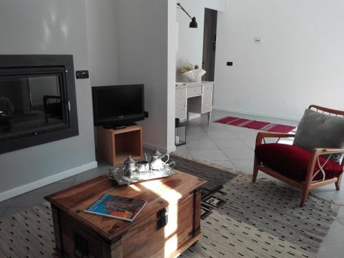 a living room with a coffee table and a tv at B&B Marana 14 Casa di Campagna in Bologna