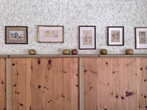 a wooden counter with framed pictures on a wall at Stern B&B & Suite Apartments in Nova Levante