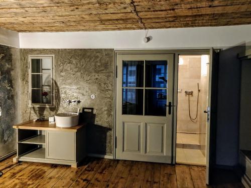 a bathroom with a white door and a sink at Hotel Kocour in Třebíč