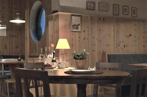 a dining room with a table with chairs and a lamp at Stern B&B & Suite Apartments in Nova Levante