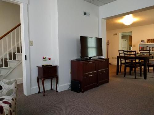 a living room with a flat screen tv on a dresser at Pearl's Place in Gettysburg