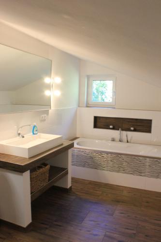 a bathroom with a sink and a tub and a mirror at Friedrichsruh 2 in Waldershof