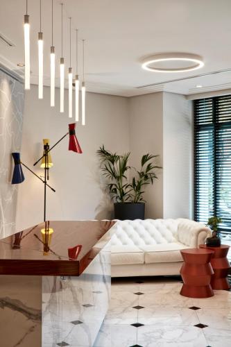 a living room with a white couch and a table at Antigon Urban Chic Hotel, Thessaloniki in Thessaloniki